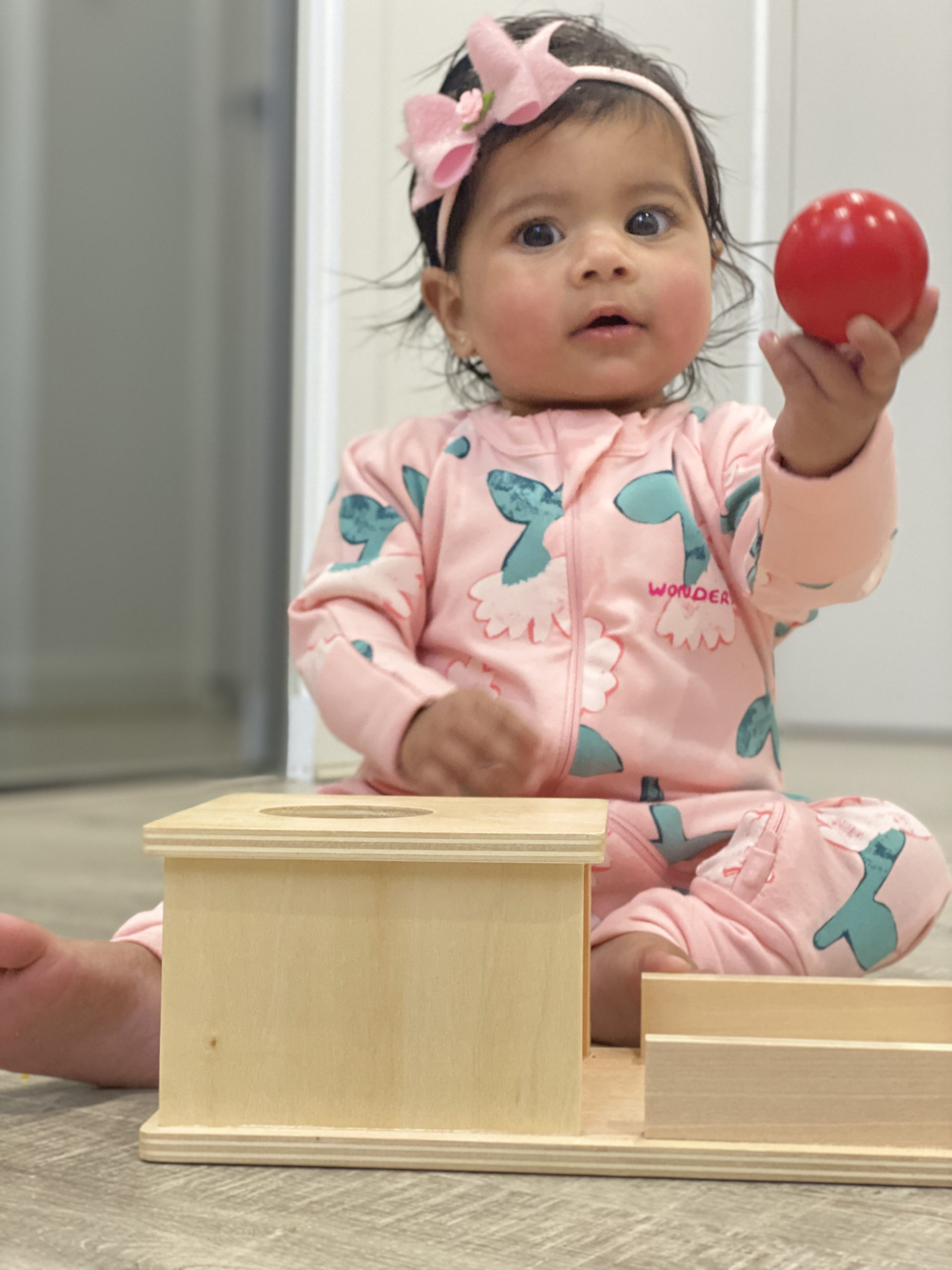 baby playing with object permanence box